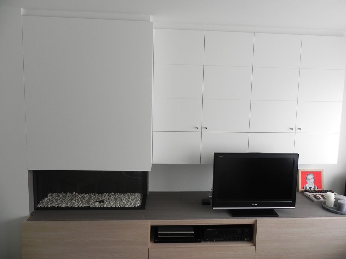 Geplaatste haardwand in laminaat in Ieper met witte bovenkasten, gashaard en houtkleurig tv-meubel