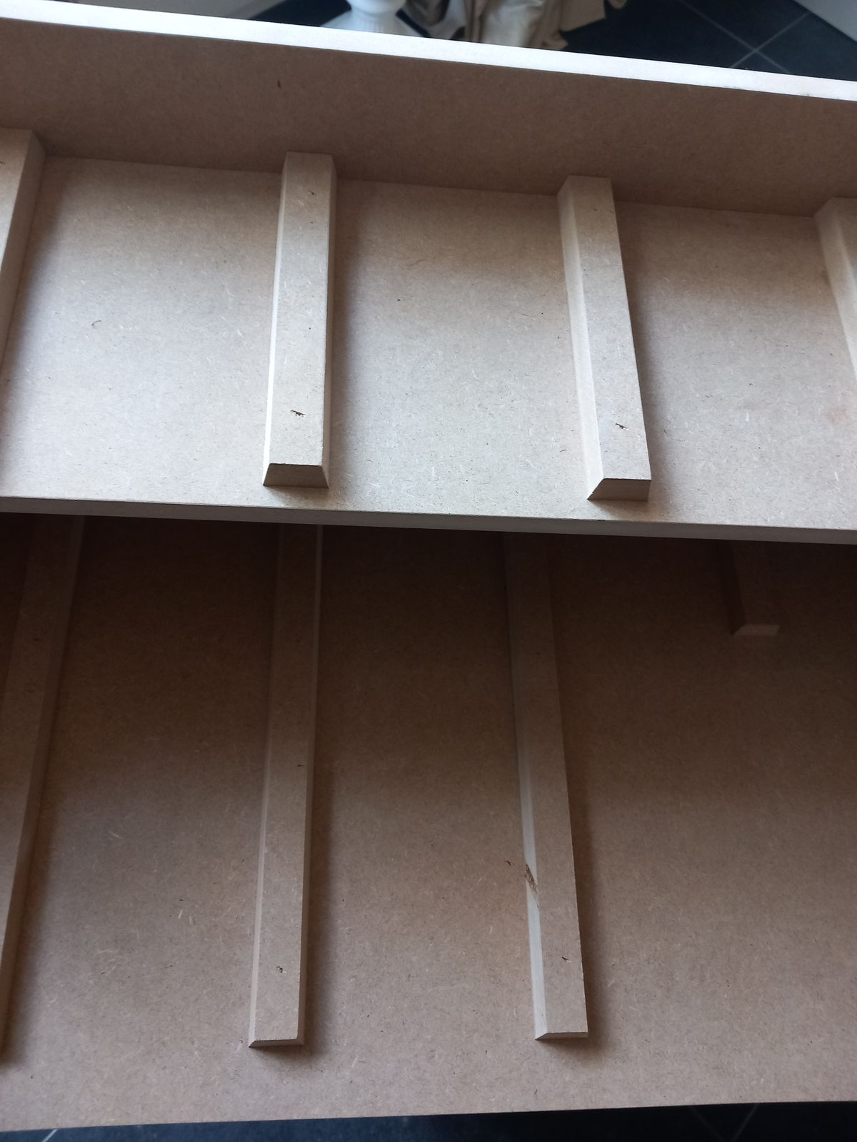 Situatie tijdens de bouw: onbehandelde mdf-planken met latjes als geleiders voor Legobakjes