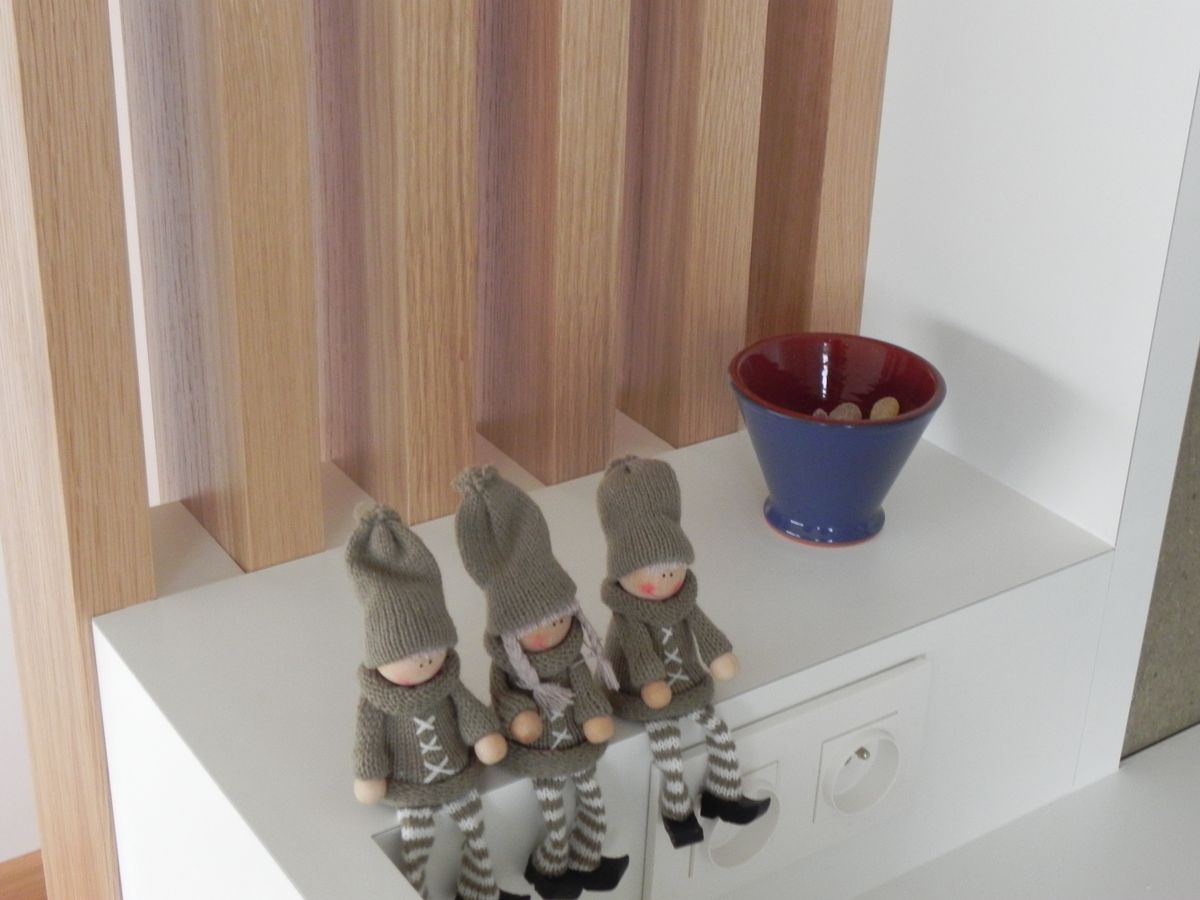 Wit tablet tegen de verticale houten latten, met ingewerkte stopcontacten en decoratieve poppetjes
