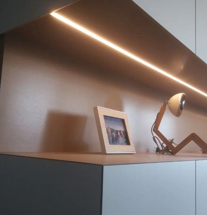Detail van de nis met ingebouwde ledstrip boven een donker blad in laminaat met decoratie