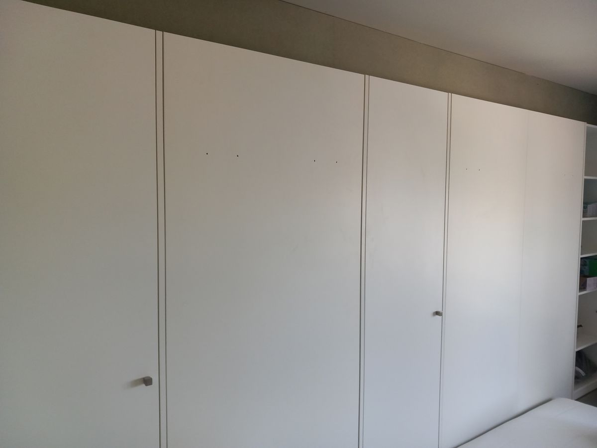 Witte kastenwand in mat laminaat met smalle grepen en geïntegreerde inklapbedden