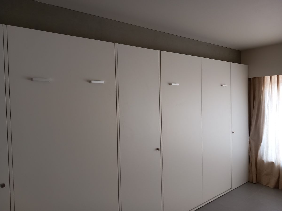 Lange witte kastenwand in mat laminaat met inklapbaar dubbel en enkel bed