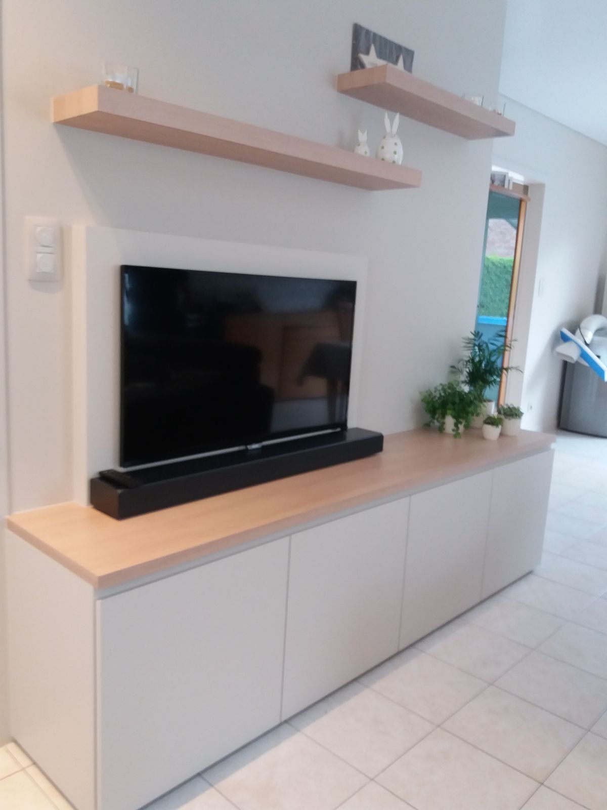 TV-meubel in Wevelgem met witte geschilderde onderkasten, blad in houtlook laminaat en zwevende wandplanken